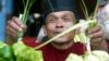 Seorang pedagang kaki lima Indonesia menjual ketupat, di Jakarta 24 November 2003, menjelang Idul Fitri. (Foto: Reuters)