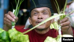 Seorang pedagang kaki lima Indonesia menjual ketupat, di Jakarta 24 November 2003, menjelang Idul Fitri. (Foto: Reuters)