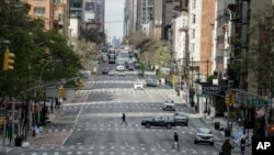 Pedestrians cross near-empty Second Avenue in New York, April 16, 2020. Gov. Andrew Cuomo extended stay-at-home restrictions Thursday through mid-May. 