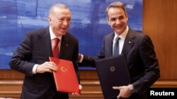 Presiden Turki Tayyip Erdogan dan PM Yunani Kyriakos Mitsotakis tersenyum setelah menandatangani deklarasi bersama untuk menjalin hubungan bertetangga yang baik di Maximos Mansion di Athena, Yunani, Kamis 7 Desember 2023.