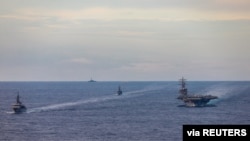 FILE - Japan Maritime Self-Defense Force training ships JS Kashima and JS Shimayuki conduct a passing exercise (PASSEX) with Nimitz-class nuclear-powered aircraft carrier USS Ronald Reagan in the South China Sea, July 7, 2020. 