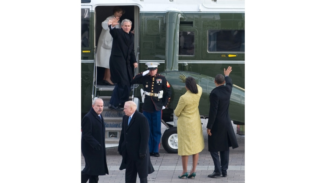 U.S. President Barack Obama (R) waves alongside first lady Michelle Obama as former President George W. Bush and Laura Bush wave as they prepare to depart the U.S. Capitol on Inauguration Day in Washington, Jan. 20, 2009.