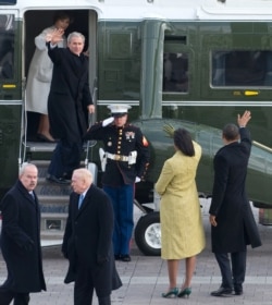 U.S. President Barack Obama (R) waves alongside first lady Michelle Obama as former President George W. Bush and Laura Bush wave as they prepare to depart the U.S. Capitol on Inauguration Day in Washington, Jan. 20, 2009.