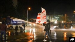 Police use a water cannon against supporters of ex-President Mikhail Saakashvili's United National Movement, protesting parliamentary election results, in Tbilisi, Georgia, Nov. 8, 2020.