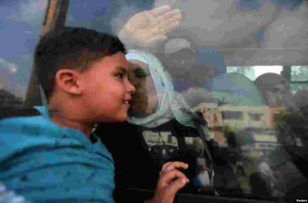 A Palestinian woman kisses her grandson through the window of a bus before she leaves for the annual Haj pilgrimage in Mecca, in Khan Younis in the southern Gaza Strip.