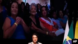 FILE - Bank of Brazil President Tarciana Medeiros speaks during her swearing-in ceremony, backdropped by a screen that shows family members watching from the audience, in Brasilia, Brazil, January 16, 2023.