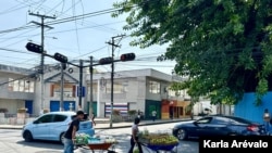 Un vendedor ambulante empuja su carretón lejos del centro histórico de San Salvador, buscando un nuevo espacio para vender. [Fotografía Karla Arévalo / VOA].