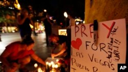 Watu wakitoa rambirambi zao katika eneo lililowekwa kwa ajili ya kuomboleza wahanga wa shambulizi la Las Vegas