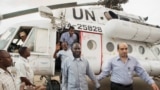 A member of the joint U.N. African Union Mission in Darfur (UNAMID), right, escorts three freed humanitarian workers out of a U.N. helicopter as they landed in El Fasher, North Darfur, Sudan, Saturday, July 19, 2014.