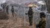 FILE - Border guard officers stand with shields during the construction of a wall along the Polish-Belarusian border in Tolcze, Poland, Jan. 27, 2022. Prime Minister Donald Tusk said on Oct. 12, 2024, the country plans to temporarily suspend the right to asylum for migrants.