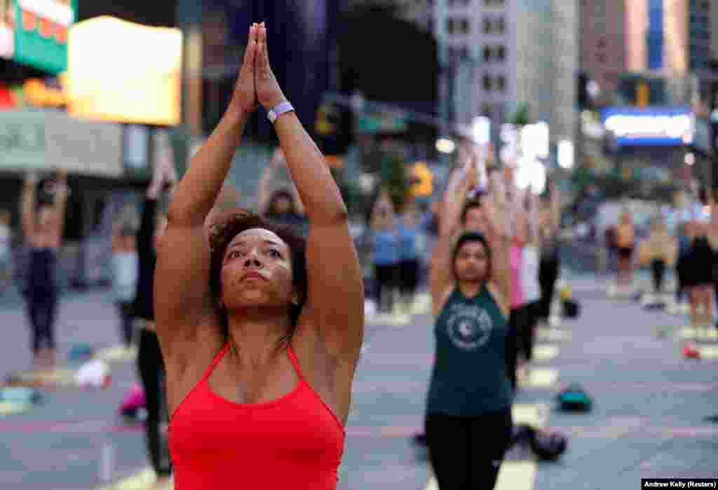 Pessoas participam no evento de celebra&#231;&#227;o do solst&#237;cio na Times Square em Nova Iorque (&quot;Solstice in Times Square: Mind Over Madness Yoga&quot;). 20 de Junho, 2021