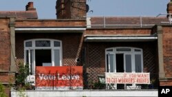 FILE - Banners of opposing views on Britain's Brexit referendum on EU membership are displayed on the balconies of two neighboring apartments in the Gospel Oak area of north London, Britain, May 27, 2016.