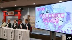 Japan Anime Tourism Association officials attend a press conference on the newly formed association in Tokyo, Sept. 16, 2016, while showing an image of a Japanese TV animation series on the screen.