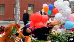 Russian President Vladimir Putin visits a memorial made for the victims of a fire in a multi-story shopping center in the Siberian city of Kemerovo, about 3,000 kilometers (1,900 miles) east of Moscow, Russia, March 27, 2018.