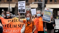 A small group of protesters march in Sydney, Saturday, June 13, 2020, during a day of demonstrations across Australia in support of the Black Lives Matter movement and refugee rights. Protesters in Sydney, Adelaide and Perth were urged to stay away…