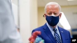 FILE - In this Feb. 11, 2021, file photo President Joe Biden looks at a model of Covid-19 as he visits the Viral Pathogenesis Laboratory at the National Institutes of Health in Bethesda, Md. (AP Photo/Evan Vucci, File)