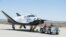 FILE - Sierra Nevada Corporation engineers and technicians prepare the firm's Dream Chaser engineering test vehicle for tow tests on a taxiway at NASA's Dryden Flight Research Center in Palmdale, California, June 27, 2013.
