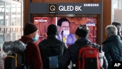 FILE - People watch a broadcast report about Lee Man-hee, a leader of Shincheonji Church of Jesus, at the Seoul Railway Station in Seoul, South Korea, March 2, 2020. Man-hee apologized for causing the "unintentional" spread of COVID-19.
