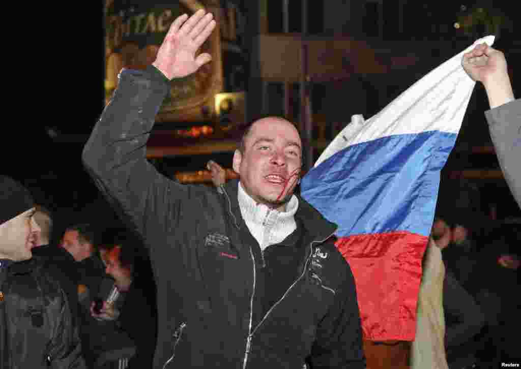 Wounded participants in a pro-Russia rally gesture during clashes with anti-war rally demonstrators in Donetsk, Ukraine, March 13, 2014. 