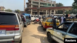 FILE - Guineans wait in line for fuel after a blast at an oil terminal in Conakry, Guinea December 19, 2023. 