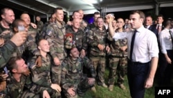 FILE - French President Emmanuel Macron celebrates with French soldiers during a Christmas dinner at Port-Bouet military camp near Abidjan, Ivory Coast, Dec. 21, 2019, during a visit to West Africa.