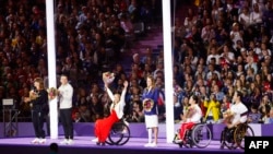 Italy's Martina Caironi (L), Malta's Vladyslava Kravchenko (3th L) and China's Yujiao Tan (2nd R) are seen during the Paris 2024 Paralympic Games closing ceremony at the Stade de France, in Saint-Denis, near Paris, Sept. 8, 2024.