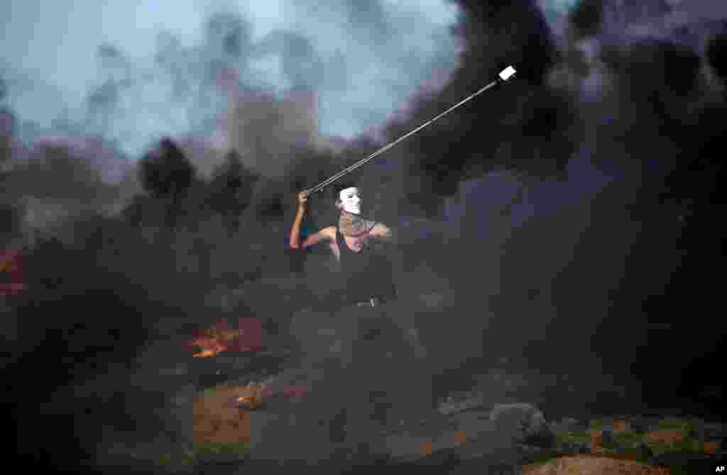 A Palestinian protester hurls stones at Israeli troops during a protest at the Gaza Strip's border with Israel.