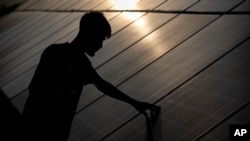 FILE - An employee checks solar panels near a hydrogen plant at Oil India Limited in Jorhat, India, Thursday, Aug. 17, 2023.