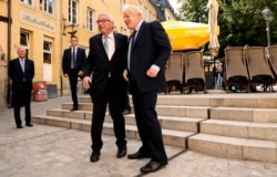 FILE - European Commission President Jean-Claude Juncker, left, shakes hands with British Prime Minister Boris Johnson prior to a meeting at a restaurant in Luxembourg, Sept. 16, 2019.