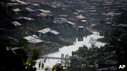 FILE - In this Dec. 21, 2017, photo, Rohingya Muslim children, who crossed over from Myanmar into Bangladesh, play on a bridge made by bamboos at Kutupalong refugee camp in Ukhiya, Bangladesh.