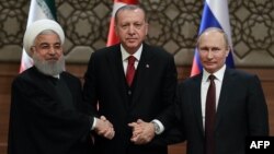 FILE - Iran's President Hassan Rouhani, from left, Turkey's President Recep Tayyip Erdogan and Russia's President Vladimir Putin shake hands after a joint press conference as part of a tripartite summit on Syria, in Ankara, April 4, 2018.