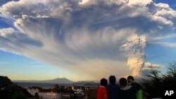 Anak-anak menonton gunung Calbuco yang meletus, dari kota Puerto Varas, Chile selatan (22/4).