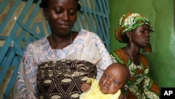 Rashidat Iyola looks at her child's new tribal marks in Ibadan, Nigeria, March 15, 2007.