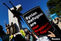 FILE - Demonstrators hold placards in support of Syrian refugees during a protest against Turkish government's recent refugee policies in Istanbul, Turkey, July 27, 2019.
