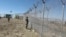 Pakistani soldiers stand guard at a newly erected fence between Pakistan and Afghanistan at Angore Adda, Pakistan, Oct. 18, 2017. 