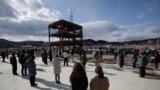 Хвилина мовчання біля руїн центру контролю за стихійними лихами у місті Мінамісанріку, у провінції Міягі, який було знищено цунамі та землетрусом.