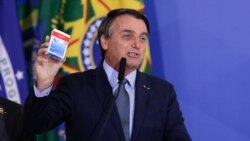 El presidente Jair Bolsonaro habla en la ceremonia de inauguración de Eduardo Pazuello como ministro de Salud mientras sostiene una caja de hidroxicloroquina, el 16 de septiembre de 2020.