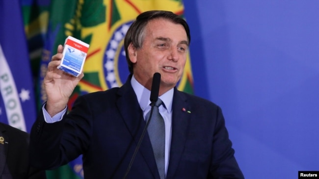 El presidente Jair Bolsonaro habla en la ceremonia de inauguración de Eduardo Pazuello como ministro de Salud mientras sostiene una caja de hidroxicloroquina, el 16 de septiembre de 2020.