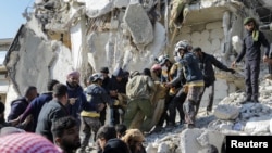 Rescuers carry a victim as the search for survivors continues in the aftermath of an earthquake, in rebel-held town of Jandaris, Syria, Feb.7, 2023. 