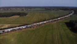 FILE - Trucks wait before the German-Polish border checkpoint Forst, as the two countries try to contain the spread of coronavirus disease, in Frauendorf, Germany, March 18, 2020.