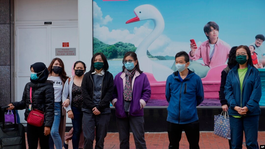 FILE - People wait to cross a street in Hong Kong, Jan. 9, 2022.