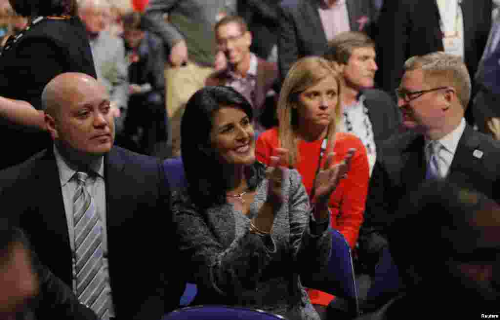 South Carolina Governor Nikki Haley applauds next to her husband, Michael, left, as she sits in the audience at the Fox Business Network Republican presidential candidates debate in North Charleston, South Carolina, Jan. 14, 2016.