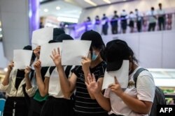 FILE - Protesters hold up blank papers during a demonstration in a mall in Hong Kong on July 6, 2020, in response to a national security law which makes political views, slogans and signs advocating Hong Kong’s independence or liberation illegal.