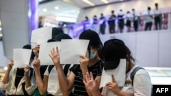 FILE - Protesters hold up blank papers during a demonstration in a mall in Hong Kong on July 6, 2020, in response to a national security law that makes political views, slogans, and signs advocating Hong Kong’s independence or liberation illegal. 