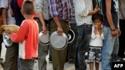 Nepalese people queue to receive food and goods at a relief camp for survivors of the Nepal earthquake in Kathmandu, May 19, 2015.