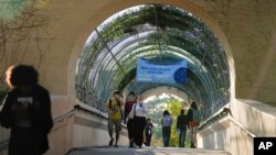 Students cross a bridge linking different sections of the campus, at New College of Florida, Tuesday, Feb. 28, 2023, in Sarasota, Fla. 