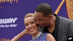 FILE - Will Smith, right, kisses Jada Pinkett Smith as they arrive at the premiere of "Aladdin" at the El Capitan Theatre in Los Angeles, May 21, 2019.