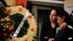 Grieving family members embrace during a wake for environmental activist Homero Gomez Gonzalez, in Ocampo, Michoacan state, Mexico, Jan. 30, 2020.