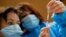 Les infirmières, Ines, à gauche, et Valérie préparent un vaccin Pfizer-BioNTech COVID-19 à administrer à un agent de santé dans un centre de vaccination contre les coronavirus à Poissy, en France, le vendredi 8 janvier 2021.