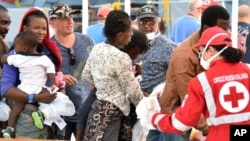 Des migrants secourus par la Croix rouge au port de Messina en Sicile, Italie, 24 aout 2015.